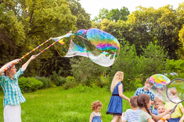 Kids birthday party at summer park with bubbles — Stock Photo, Image