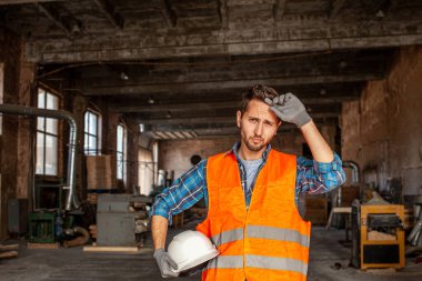 Young engineer standing indoors an old woodworking plant