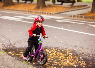 Bisiklette oturan küçük bir çocuğun portresi.