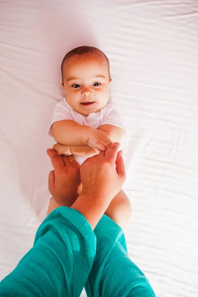 Gimnasia con el bebé, vista superior en la cama — Foto de Stock