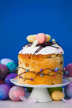 Easter cake on cake stand with painted eggs near