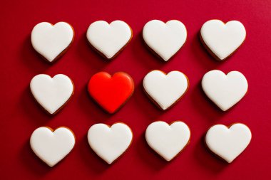 Valentines day concept. Red background with white heart shape cookies