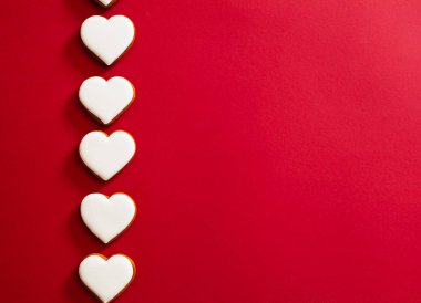 Five white hearts on red paper sheet