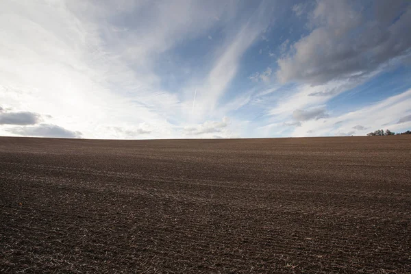 Plowed field prepared for planting crops at sunset — Stock Photo, Image