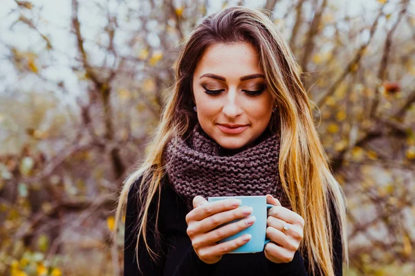 Pretty woman with manicured hands holding cup of hot tea outdoors. Autumn day. — ストック写真