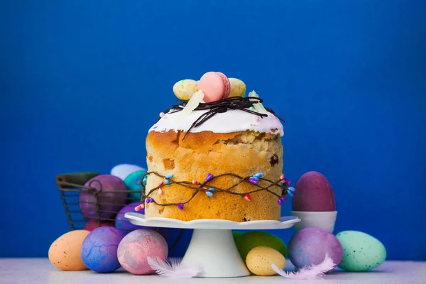 Пасхальный торт на тарелке и разноцветные яйца — стоковое фото