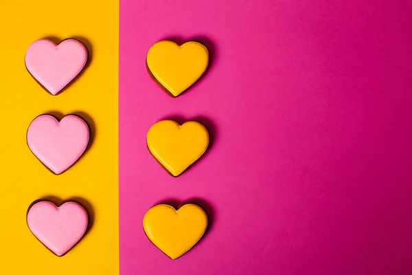 Pink and yellow hearts on colorful paper background — Stok fotoğraf
