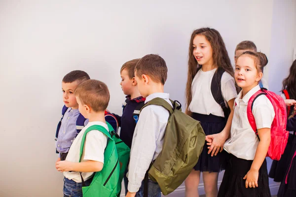 Группа счастливых маленьких школьников в школе — стоковое фото