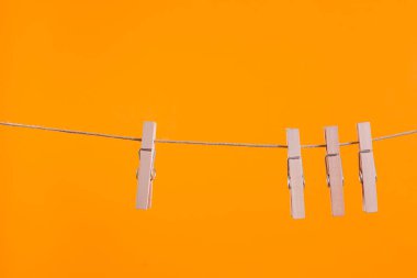 Wooden clothespins hanging on a clothesline rope
