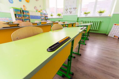 Wide angle desks and chairs in classroom.