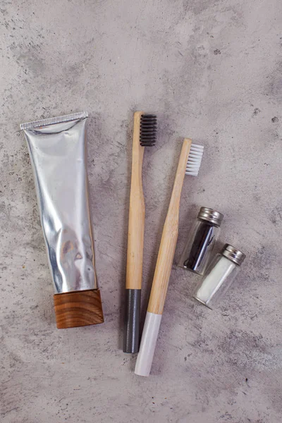 Brosses à dents naturelles en bambou, dentifrice, fil dentaire sur fond de marbre gris — Photo