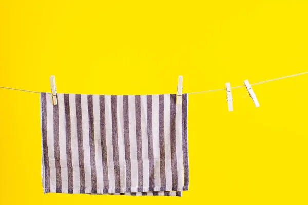 Kuchyňský ručník po umytí přes žluté pozadí. Vysmívej se designu. Čisticí služby — Stock fotografie