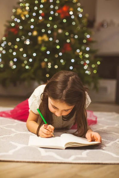 Écolière écrivant Noël saluant pour ses grands-parents — Photo