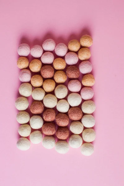 Large amount of felt balls on pink background — 스톡 사진