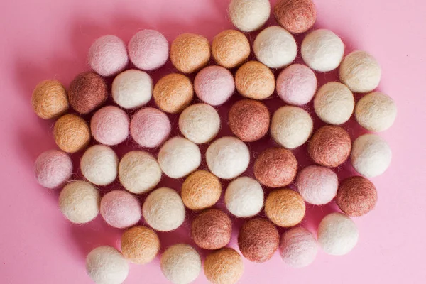 Multicolor felt balls spilled on pink cover — 스톡 사진