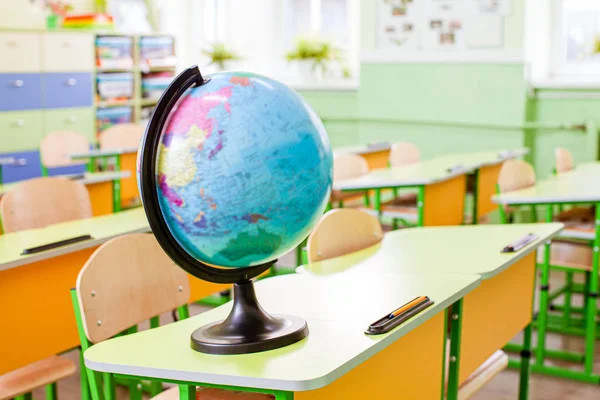 Земной шар на желтом столе в классе — стоковое фото