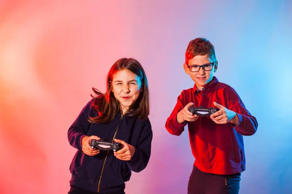 Excited kids with joysticks playing an interesting virtual game — Stock Photo, Image