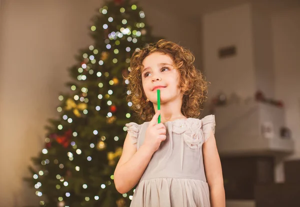 Liten lockig flicka väntar på julmagi — Stockfoto