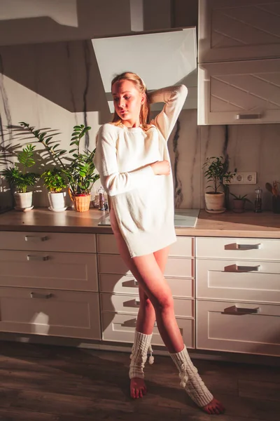 Chica de pie en la cocina en los rayos de sol —  Fotos de Stock