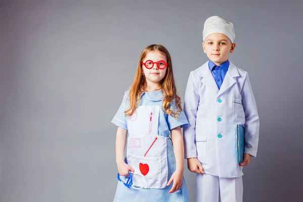 Cute boy and girl in medical uniform playing like doctors.