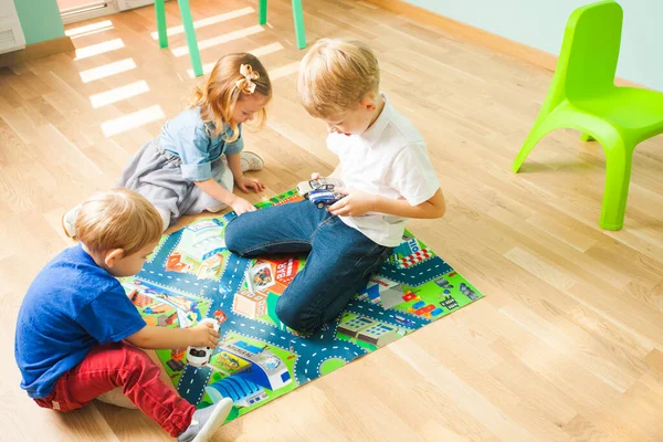 幼児は自宅の床で一緒に遊んでいます。家庭や保育園の子どもたち. — ストック写真