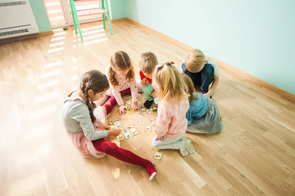 Les enfants jouent et apprennent ensemble. Jeu éducatif pour les enfants. Carte avec animaux maman et bébé . — Photo