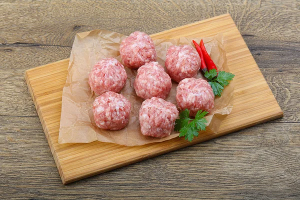 Raw meatballs on chopping board — Stock Photo, Image