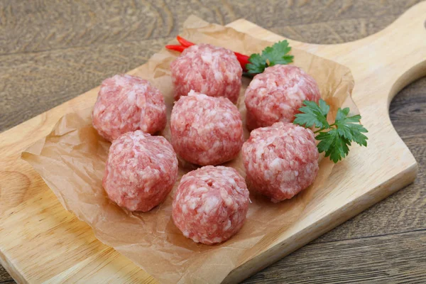 Albóndigas crudas sobre tabla de cortar —  Fotos de Stock