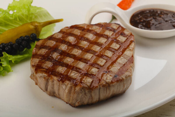 Grilled beef steak with pepper sauce and salad leaves
