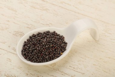 Kase ahşap arka plan üzerinde siyah hardal tohumu yığın