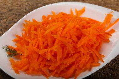 Rendelenmiş havuç yığın içinde kase ahşap arka plan üzerinde