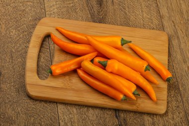 Sıcak sarı biber yığın ahşap arka plan üzerinde