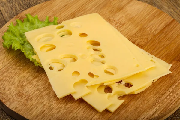 Ahşap Arka Plan Üzerinde Dilimlenmiş Lezzetli Peynir Salata Yaprakları — Stok fotoğraf