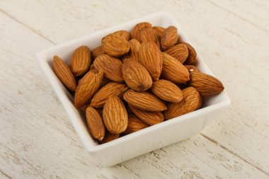 Kase üzerinde ahşap arka plan içinde badem fındık