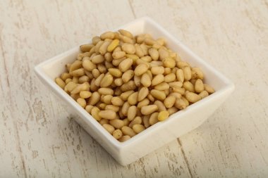 Sedir fındık yığın içinde kase ahşap arka plan üzerinde