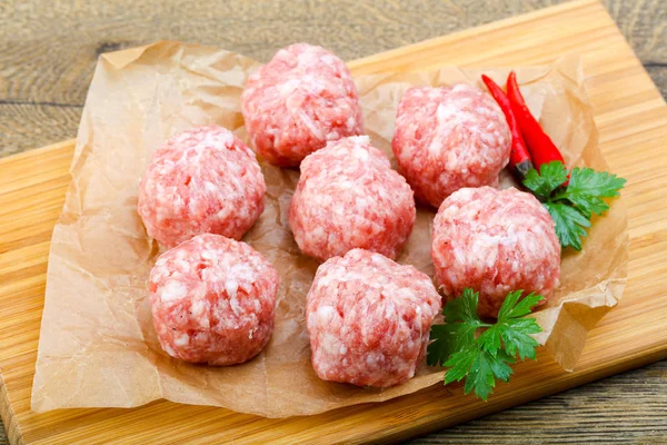 Albóndigas crudas sobre tabla de madera —  Fotos de Stock