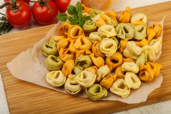 Tortellini crudo sobre tabla de madera — Foto de Stock