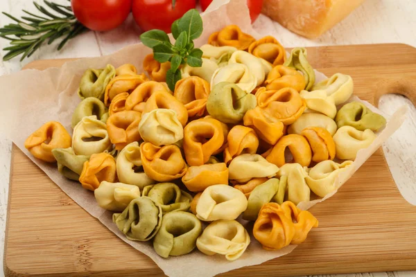 Tortellini crudo sobre tabla de madera — Foto de Stock