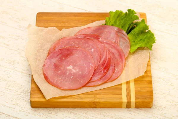 Нарізана ковбаса з листям салату — стокове фото