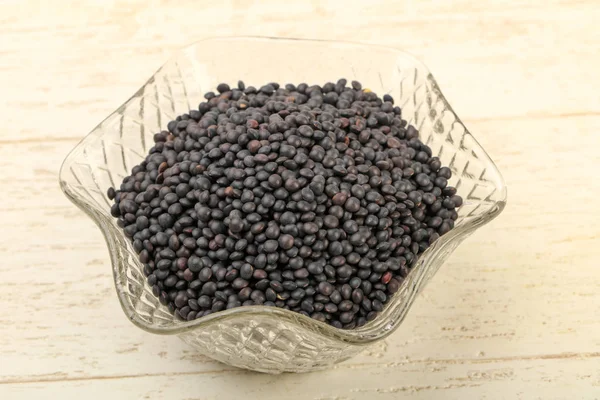 Black lentils in the bowl — Stock Photo, Image