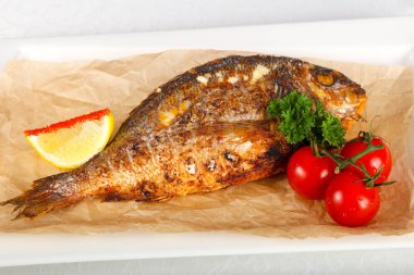 Dorada balık beyaz plaka üzerinde kavrulmuş