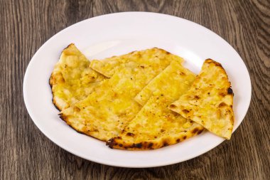Naan peynir ve sarımsak ile. Hint ekmek plaka üzerinde ahşap arka plan