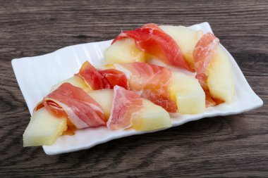 Ahşap arka plan üzerinde prosciutto ile kavun 
