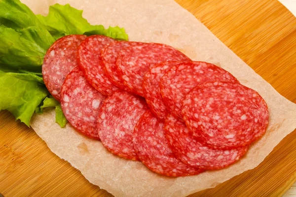 Salsicha de salame fatiada em papel de cozinha — Fotografia de Stock