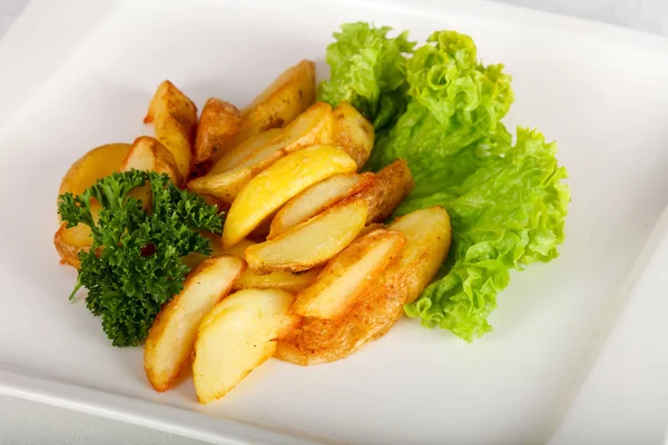 Ahşap arka plan üzerine maydanoz ile fırında patates