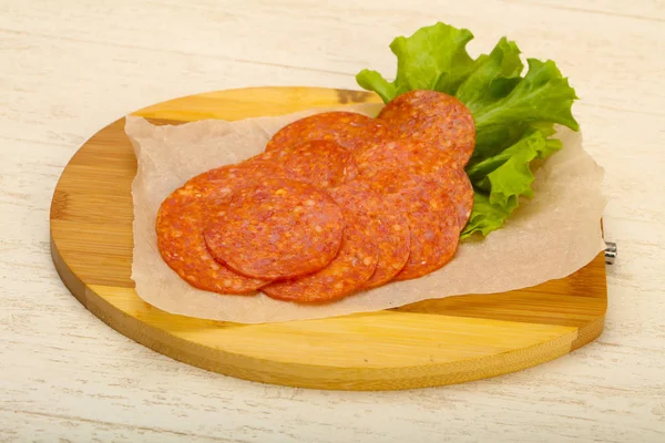 Wurst in Scheiben mit Salatblättern — Stockfoto