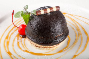 Çikolatalı kek kiraz ve nane beyaz plaka üzerinde