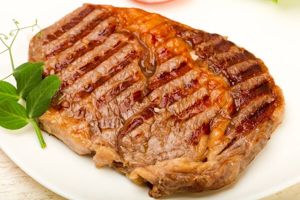 Grilled Rib eye steak on wooden table background