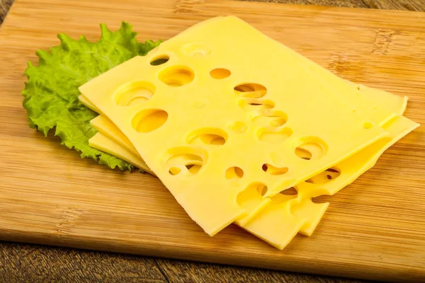 Sliced cheese with salad leaves — Stock Photo, Image