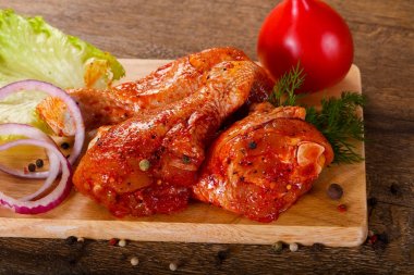 Izgara ve barbekü ahşap arka plan üzerinde Marine edilmiş tavuk uyluk